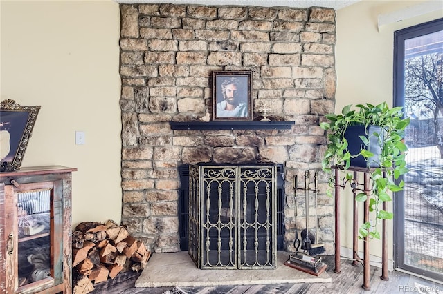 interior details featuring hardwood / wood-style flooring and a stone fireplace