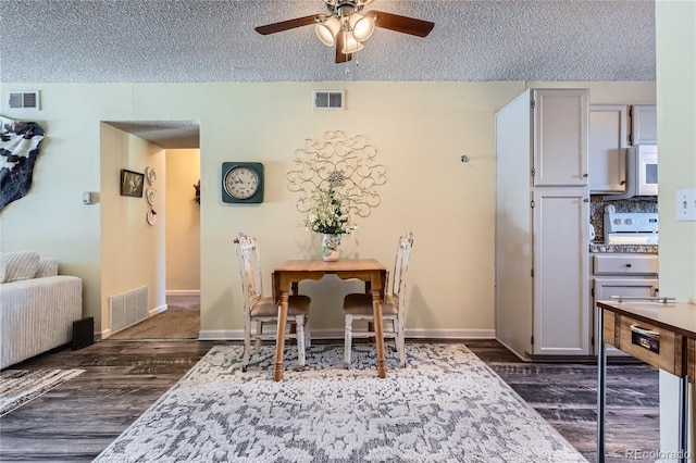 dining area featuring dark hardwood / wood-style flooring, a textured ceiling, and ceiling fan