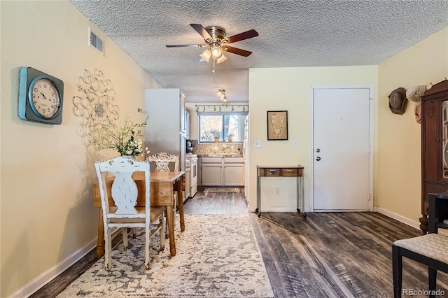 dining space featuring a textured ceiling, dark hardwood / wood-style floors, and ceiling fan