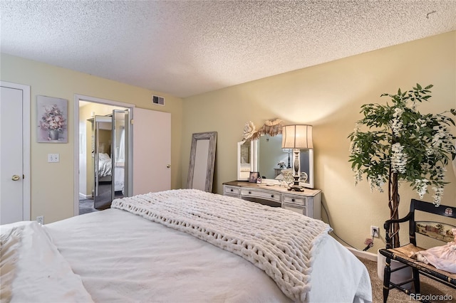 bedroom with a textured ceiling and carpet floors