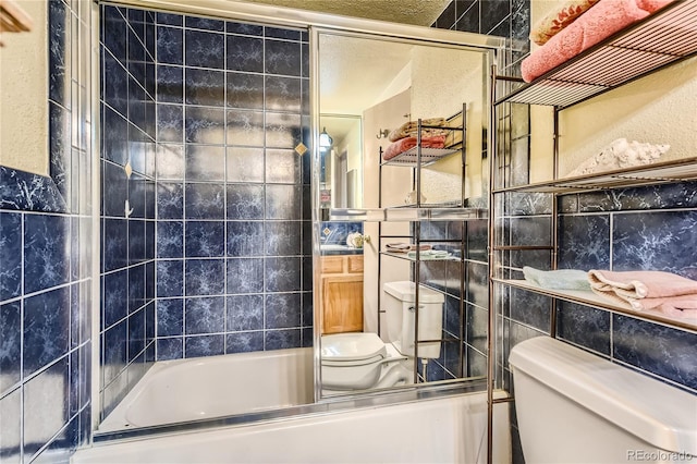 bathroom with toilet, tile walls, and enclosed tub / shower combo