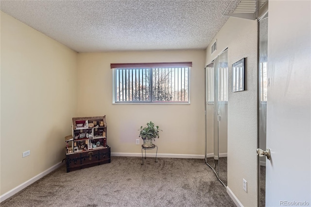 unfurnished room with carpet flooring and a textured ceiling