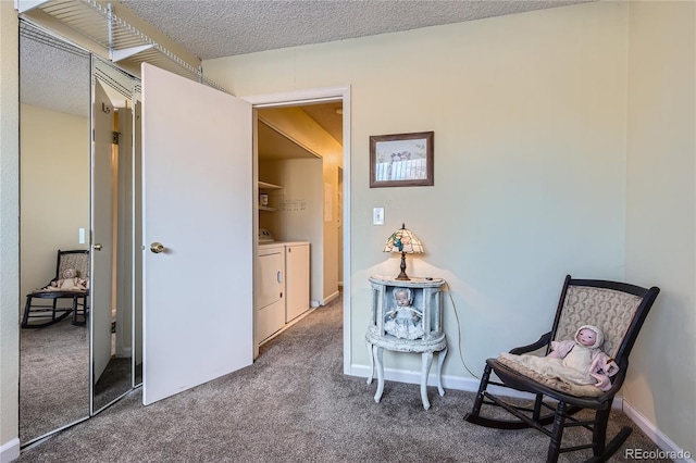 living area featuring carpet, a textured ceiling, and washing machine and clothes dryer