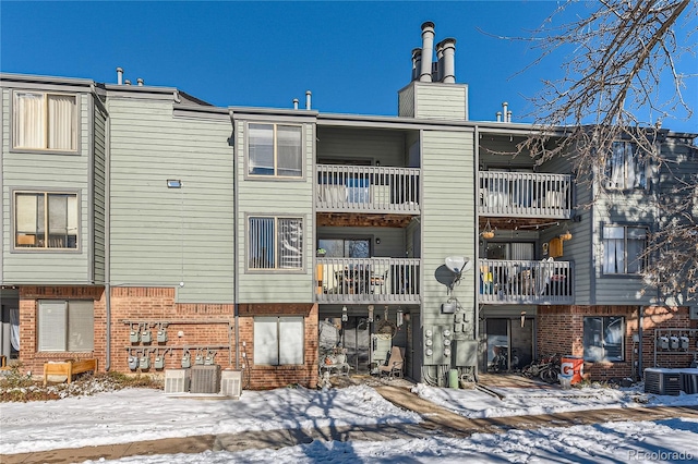 snow covered property featuring central AC unit