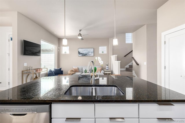1928 W 67th Pl, Denver, CO 80221 - kitchen with stainless steel dishwasher, a sink, white cabinets, open floor plan, and ceiling fan