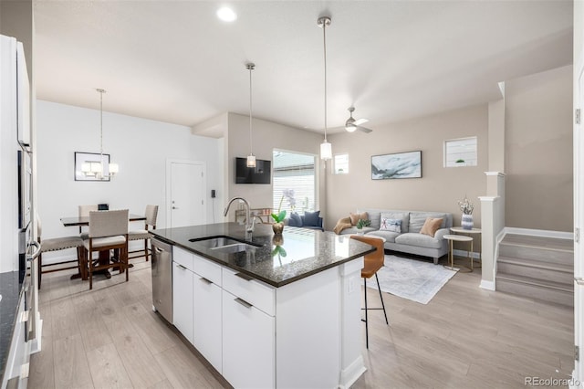 1928 W 67th Pl, Denver, CO 80221 - kitchen with a sink, dishwasher, light wood-style floors, a center island with sink, and white cabinetry