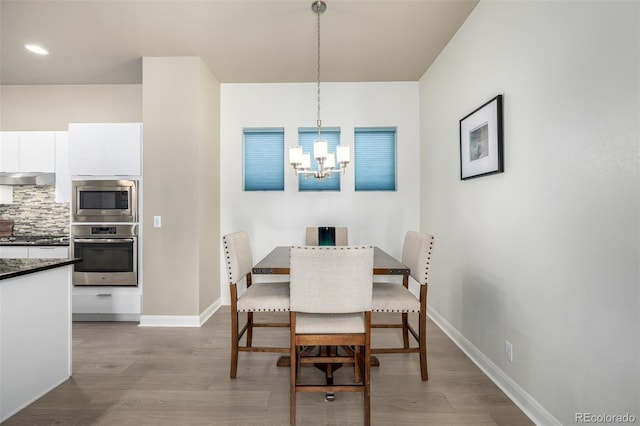 1928 W 67th Pl, Denver, CO 80221 - dining space with wood finished floors, a chandelier, baseboards, and recessed lighting