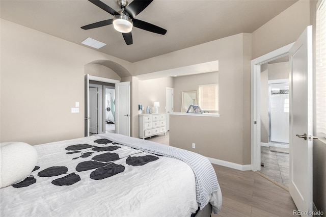 1928 W 67th Pl, Denver, CO 80221 - bedroom featuring light wood-type flooring, ceiling fan, arched walkways, and baseboards