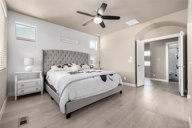 1928 W 67th Pl, Denver, CO 80221 - bedroom with baseboards, light wood-style floors, and arched walkways