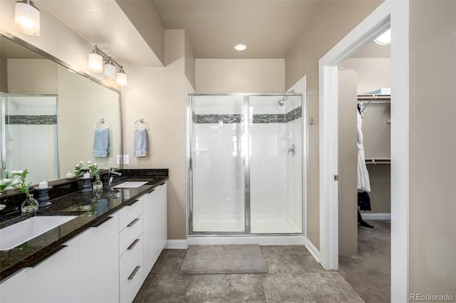 1928 W 67th Pl, Denver, CO 80221 - bathroom with a shower stall, a spacious closet, baseboards, and double vanity