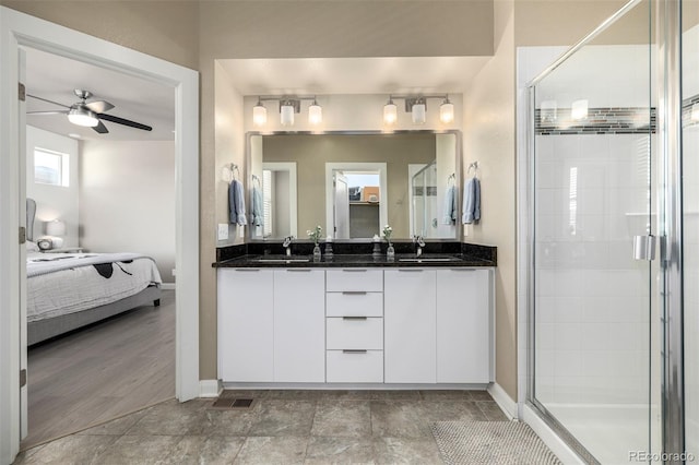1928 W 67th Pl, Denver, CO 80221 - ensuite bathroom featuring a ceiling fan, a stall shower, baseboards, and double vanity