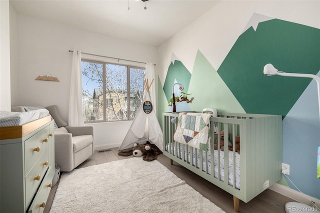 1928 W 67th Pl, Denver, CO 80221 - bedroom with a nursery area, baseboards, and wood finished floors