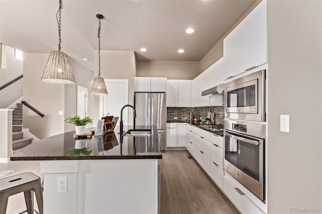 1928 W 67th Pl, Denver, CO 80221 - kitchen featuring appliances with stainless steel finishes, recessed lighting, white cabinetry, decorative backsplash, and dark wood-type flooring