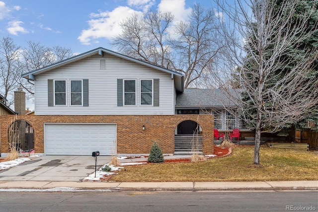 tri-level home with a garage and a front yard