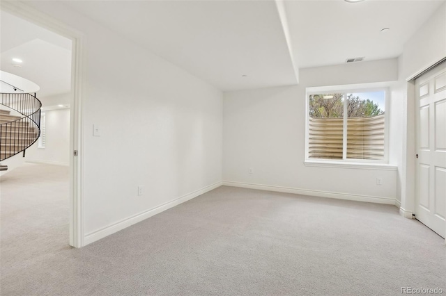 empty room featuring carpet flooring, visible vents, baseboards, and stairs