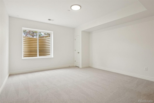 empty room featuring carpet, visible vents, and baseboards