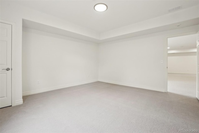 spare room with carpet, visible vents, and baseboards