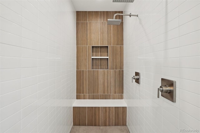 full bath with a tile shower and tile walls