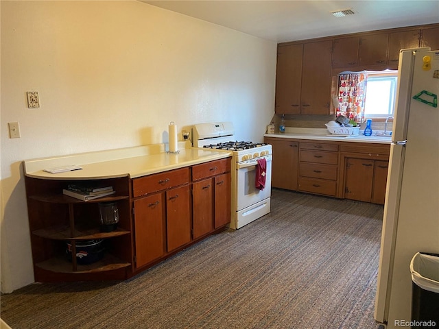12729 Desert Dr, Sterling, CO 80751 - kitchen with white appliances, light countertops, dark carpet, and open shelves