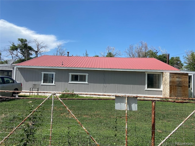 12729 Desert Dr, Sterling, CO 80751 - view of side of home with a metal roof and a yard