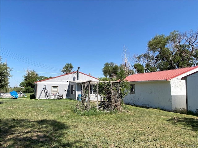 12729 Desert Dr, Sterling, CO 80751 - back of house with a lawn and a metal roof