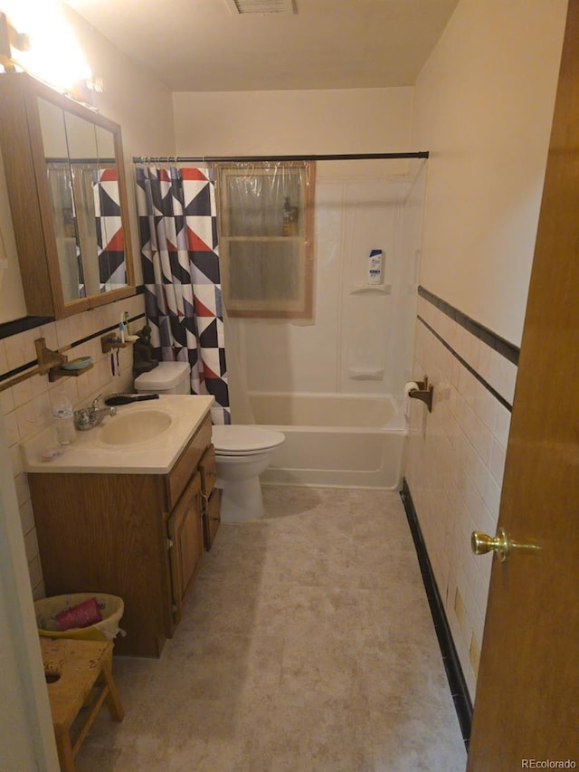 12729 Desert Dr, Sterling, CO 80751 - bathroom with tile walls, vanity, shower / bath combo, and a wainscoted wall
