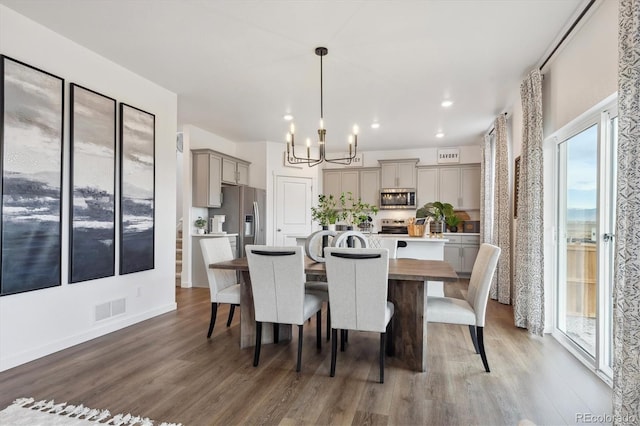 dining area with an inviting chandelier and hardwood / wood-style flooring