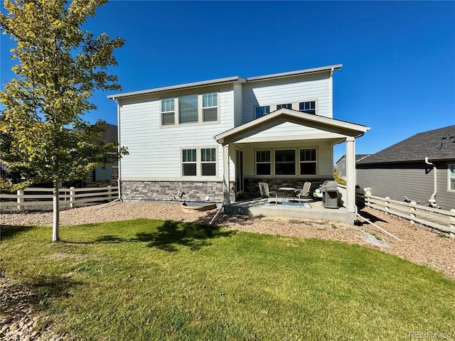 back of house featuring a lawn and a patio