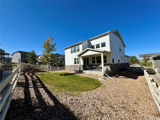 back of property with a yard and a patio