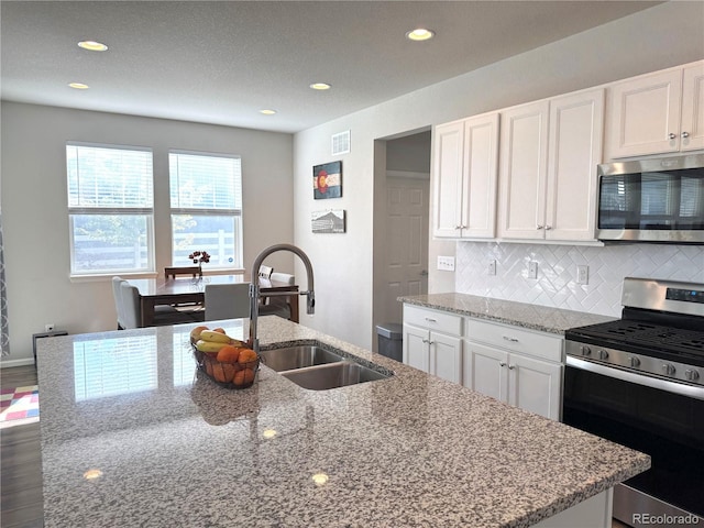 kitchen featuring appliances with stainless steel finishes, sink, dark hardwood / wood-style flooring, and white cabinetry