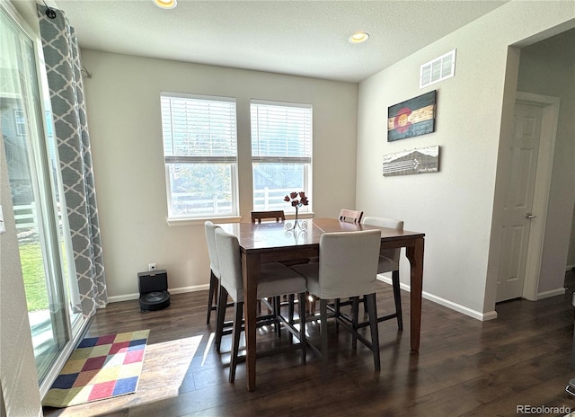 dining area featuring a textured ceiling and dark hardwood / wood-style flooring