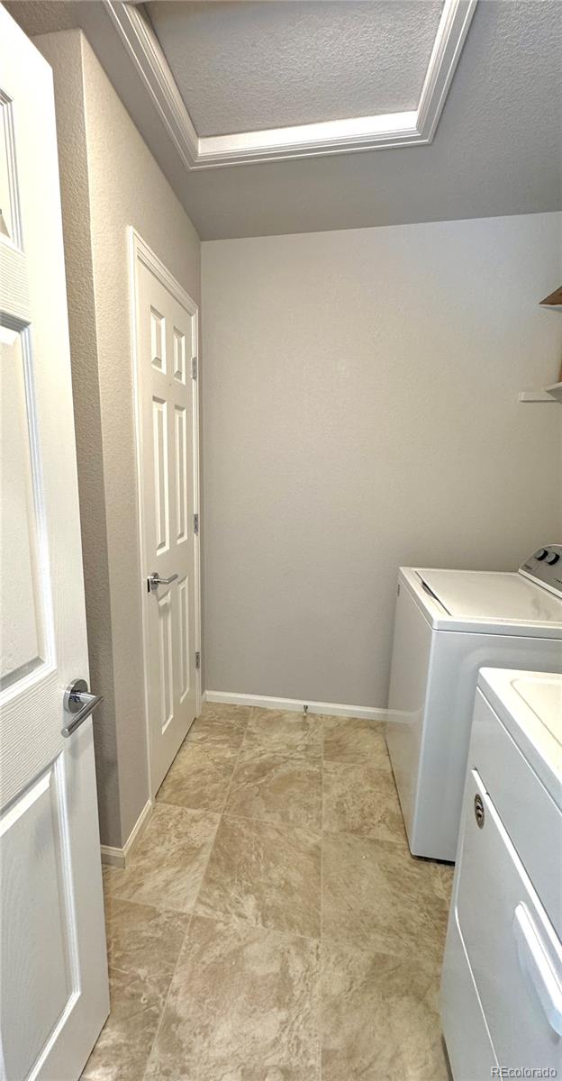 clothes washing area featuring separate washer and dryer and a textured ceiling