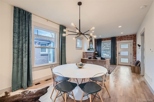 dining area featuring visible vents, baseboards, an inviting chandelier, and light wood finished floors