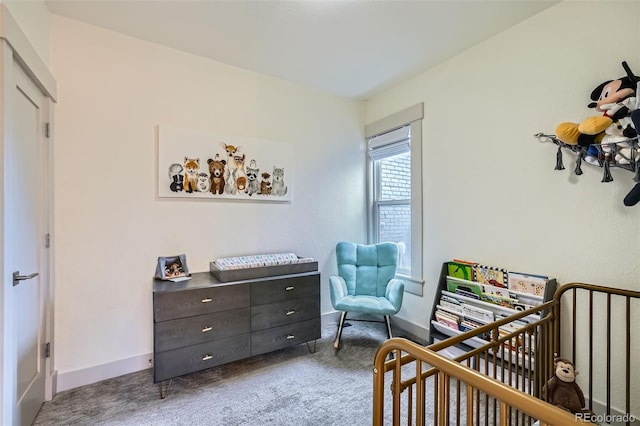 bedroom featuring baseboards, a crib, and carpet