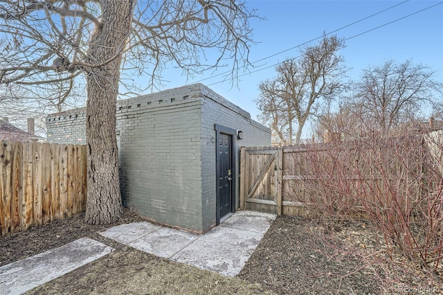 view of shed featuring a fenced backyard and a gate