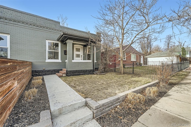 view of front facade with brick siding and fence