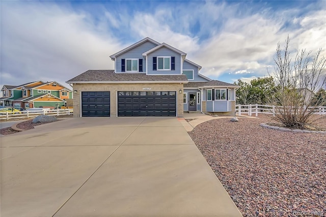 view of front of house featuring a garage, concrete driveway, roof with shingles, and fence