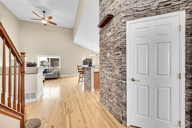 hall featuring light wood-style floors, visible vents, stairway, and an inviting chandelier