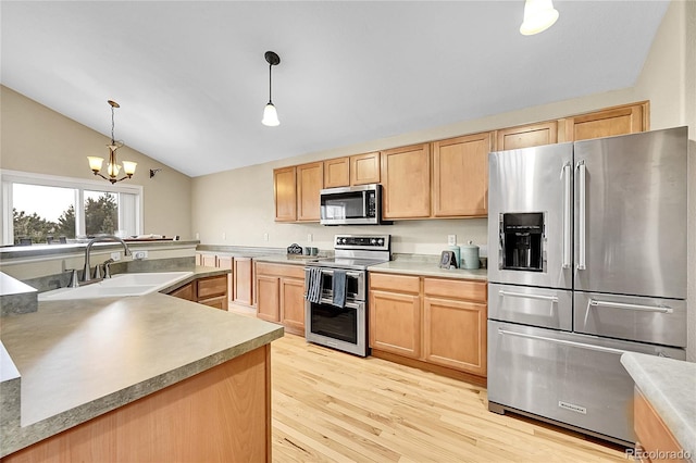 kitchen featuring lofted ceiling, light wood-style flooring, a sink, appliances with stainless steel finishes, and light brown cabinetry