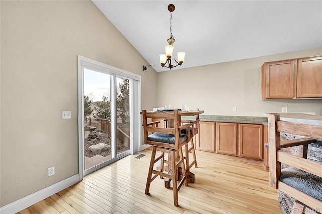 dining room featuring baseboards, visible vents, lofted ceiling, light wood-style floors, and a notable chandelier