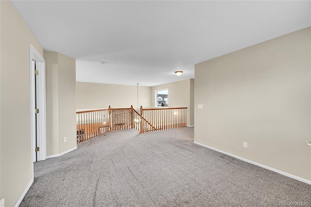 unfurnished room with baseboards and carpet flooring