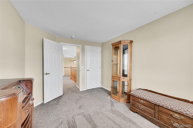 carpeted bedroom with baseboards and a textured ceiling