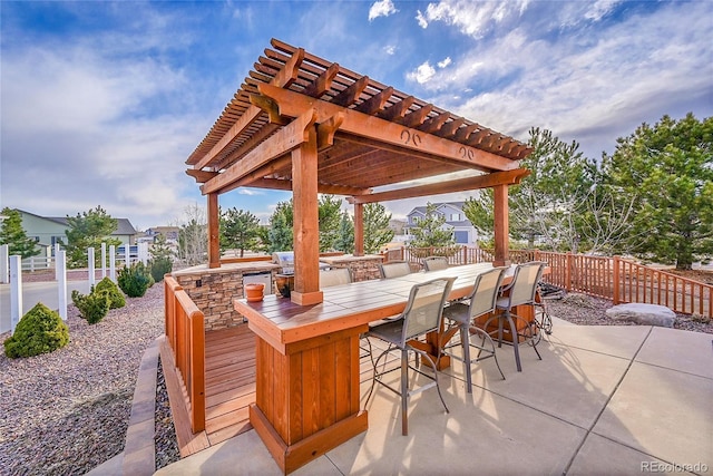 view of patio / terrace featuring outdoor dry bar, fence, and a pergola