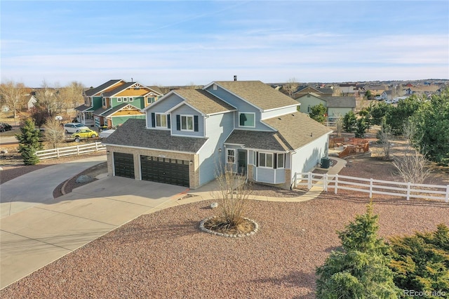 view of front facade with driveway, a shingled roof, and fence