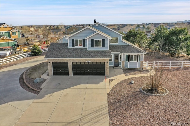 split level home featuring brick siding, a shingled roof, fence, driveway, and a residential view