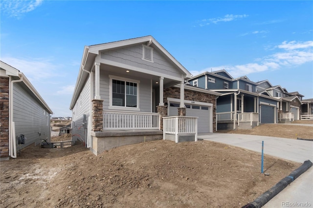 2143 Peralta Loop, Castle Rock, CO 80104 - view of front facade with covered porch, a garage, concrete driveway, and stone siding