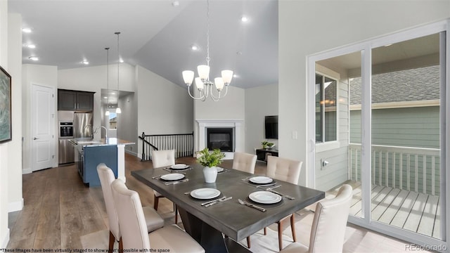 2143 Peralta Loop, Castle Rock, CO 80104 - dining area with light wood finished floors, a chandelier, high vaulted ceiling, and a glass covered fireplace