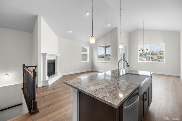 2143 Peralta Loop, Castle Rock, CO 80104 - kitchen featuring dishwasher, wood finished floors, lofted ceiling, a sink, and dark brown cabinetry