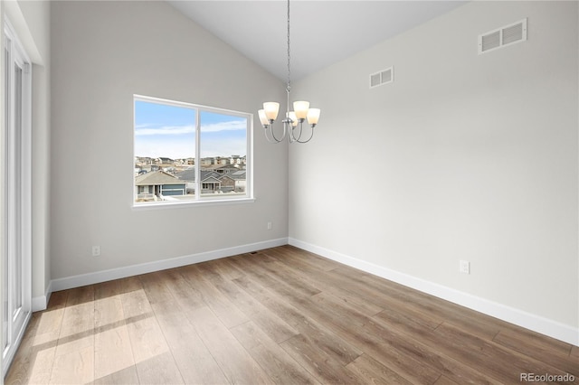 2143 Peralta Loop, Castle Rock, CO 80104 - empty room with a chandelier, wood finished floors, baseboards, and vaulted ceiling