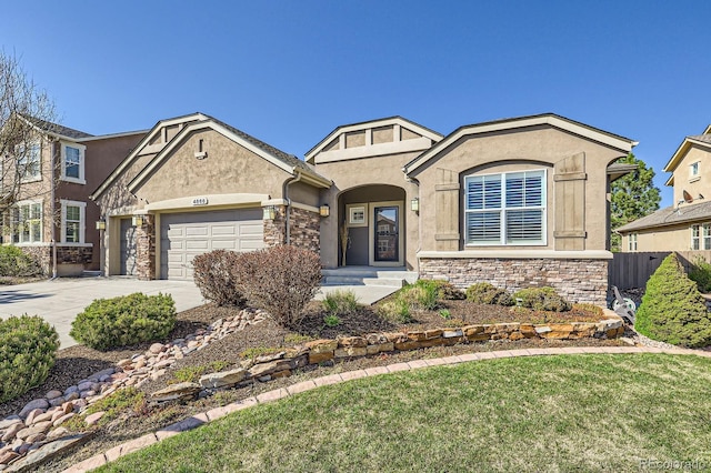 4866 Rainbow Gulch Trl, Colorado Springs, CO 80924 - view of front of property featuring an attached garage, stucco siding, stone siding, and concrete driveway